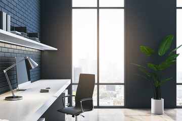 Side view of contemporary dark home office interior with workplace, window with city view and brick...