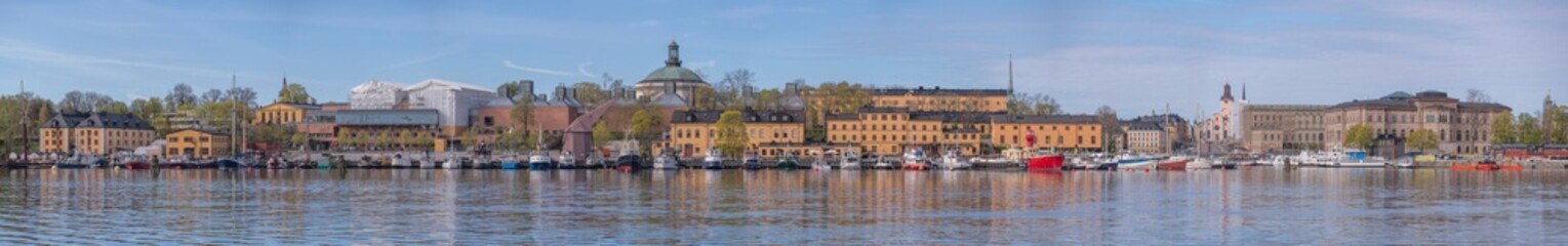 Panorama with mooring sail ships in the bay Ladugårdslandsviken, the island Skeppsholmen with old maritime buildings, a sunny summer morning in Stockholm © Hans Baath