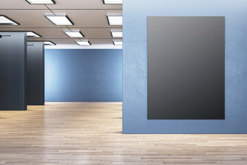 An empty black picture frame on a blue textured wall in a gallery with wood flooring and ceiling lights. 3D Rendering