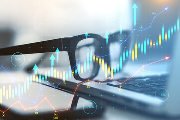 Financial charts overlay on a blurred work desk, digital-style on a blue graphical background,...