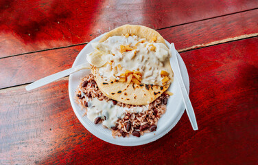 Gallopinto with Quesillo served on wooden table. Top view of traditional Gallopinto with quesillo on the table. typical nicaraguan foods