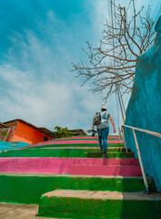 Man climbing multicolored steps. Rear view of a person climbing stairs, Nagarote.