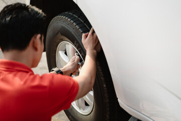 A man is inflating a tire with a tire inflator