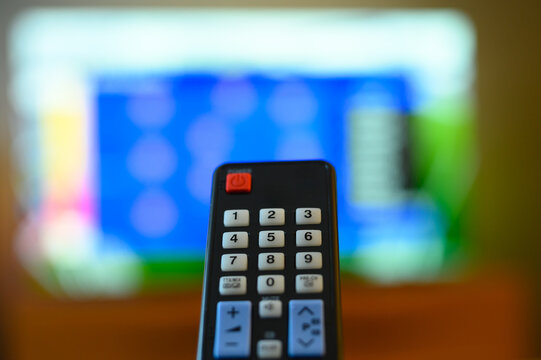 Pilot do nowoczesnego telewizora na tle okna z ustawieniami na ekranie w domu, problem z sygnałem TV 