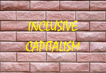 Business inclusive capitalism concept. Copy space. Words Inclusive capitalism written on a red decorative brick