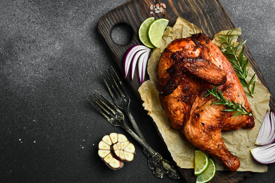 Grilled chicken with rosemary and spices on a wooden board. Traditional festive dish. - Powered by Adobe