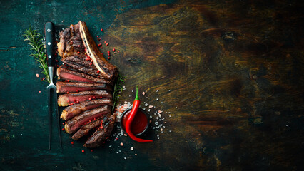 Sliced grilled meat steak Rib eye medium rare set, on wooden serving board. Top view.