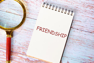 FRIENDSHIP TEXT on a notebook that lies on vintage boards