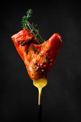 Baked chicken wings with thyme, spices and ketchup. On a fork. Traditional Buffalo Chicken Wings.
