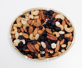 top view of wooden bowl with mixed nuts on white table
