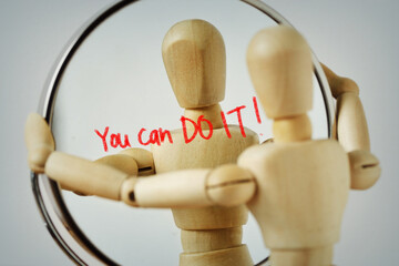 Wooden mannequin looking at himself in the mirror with the motivational message You can Do it! -...