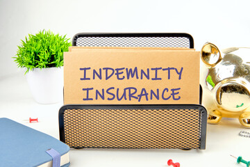 Business concept. INDEMNITY INSURANCE written on the envelope in a stand in front of a white background