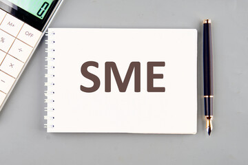 Conceptual image. Business Acronym SME as Subject Matter Expert. on a white notebook on a gray background