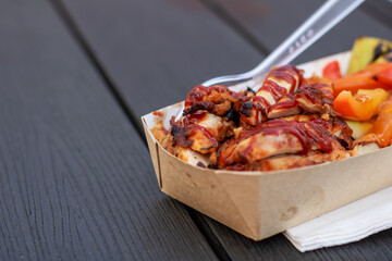 Fast food container with chicken, vegetables, and fork for convenience