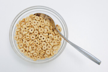 Loops cereals served in glass bowl with spoon on white background