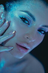 Woman glows in the evening light with enchanting, cosmic themed glitter makeup on her face and hands