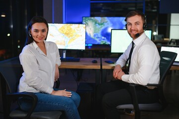 Center of dispatching maintenance. Portrait of cheerful woman and man working via headset...