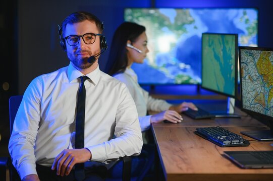 Male Data Scientist Works on Personal Computer Control and Monitoring Room. Map Surveillance of People Walking on City Streets