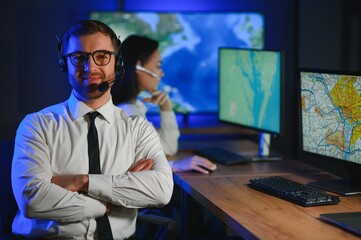 Center of dispatching maintenance. Portrait of cheerful woman and man working via headset...
