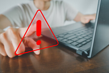 Hand pointing to Red triangle caution sign or attention sign and use laptop for work or business concept for Cybersecurity Awareness,Risk and Vulnerability,Warning and Caution,Attention and Alertness.