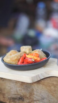 vertical video portrait, fried gehu with red chilies, a typical Indonesian food