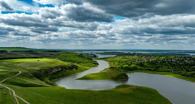 aerial hyperlapse over prut river at varatic village with fast moving clouds at the north of moldova