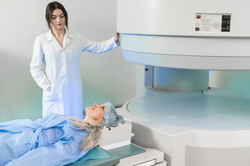 Woman doctor and patient in the MRI room. female assistant preparing adult female patient for MRI scan	