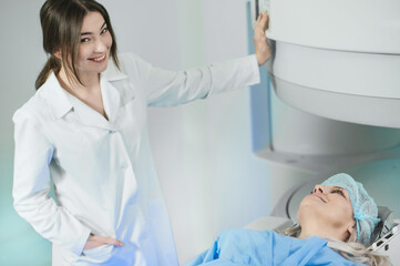 Woman doctor and patient in the MRI room. female assistant preparing adult female patient for MRI scan	