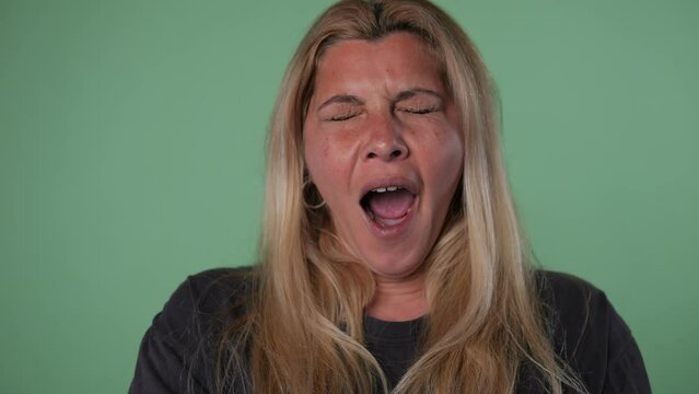 Portrait of a middle-aged caucasian blonde woman yawning. Slow motion