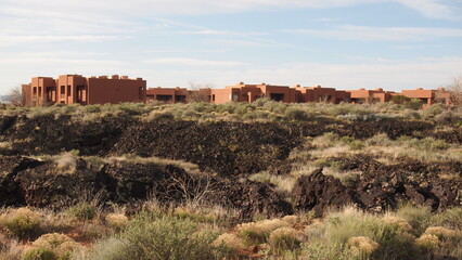 Obraz premium Desert architecture in the wilderness; red buildings in meadows and the desert; building structures in Utah; design and architecture; terracotta apartment structures; architecture photography