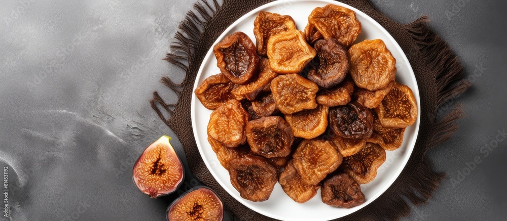 Poster Top view of a plate of dried figs on a grey background with ample space for text creating a copy space image The figs exude healthiness and nutrition
