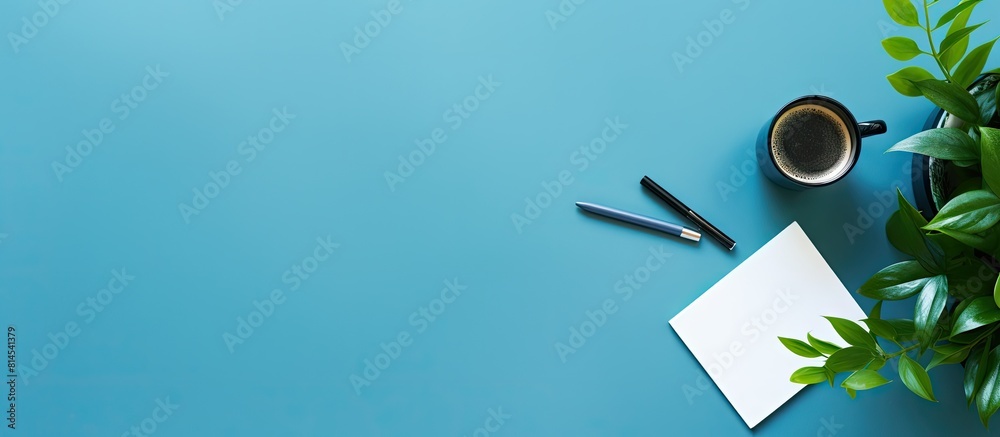 Fototapete The copy space image shows a blue table background with a top view of an office desk It includes a notebook plastic plant smartphone and keyboard representing the concept of a creative designer