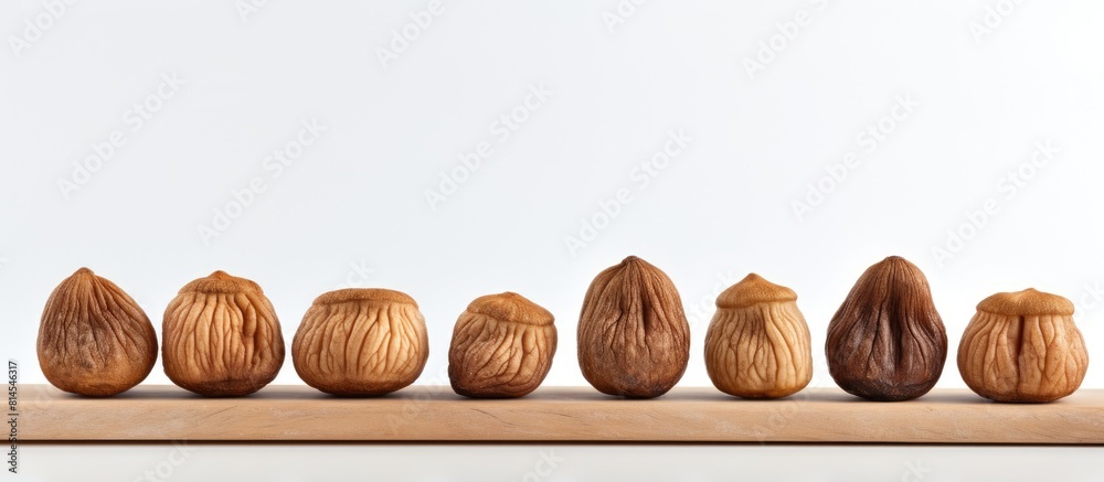 Poster A minimal composition of whole dried figs in a row isolated on a light background providing copy space for additional content