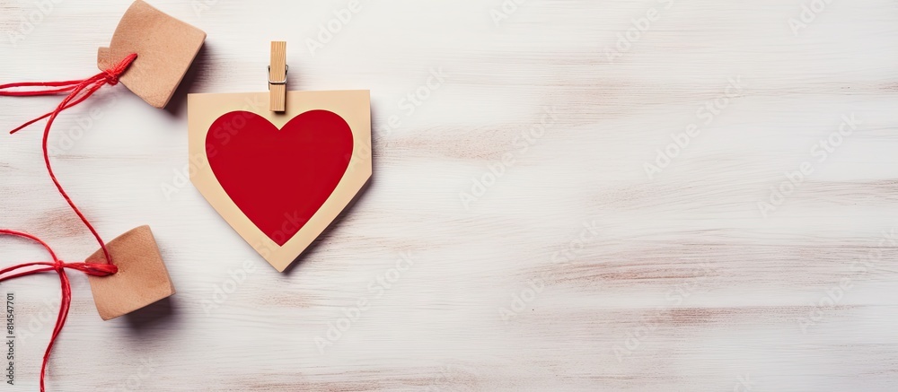 Aufkleber Valentine s day design with a heart shaped wooden clothespin and a wooden photo frame on a gray wall creating a perfect copy space image 115 characters