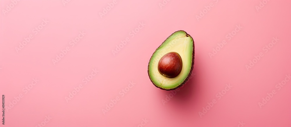Poster a fresh avocado seen from above rests on a pink background leaving ample room for other elements in 
