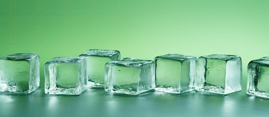 Copy space image of ice cubes arranged on a green background