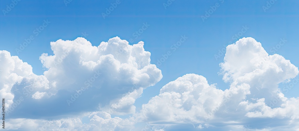 Poster The serene light blue sky is adorned with fluffy clouds creating a picturesque natural backdrop There is ample copy space in the image