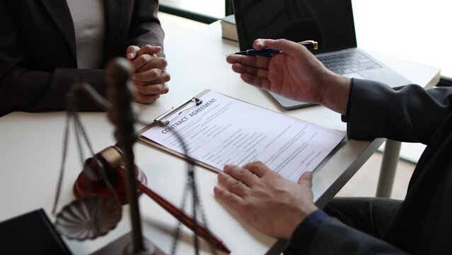 Lawyer is providing legal advice to a client. Legal advisor is discussing and explaining the terms of the legal agreement contract document before signing. Legal processing services.