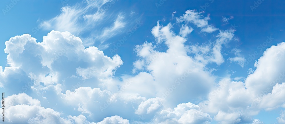 Poster The serene light blue sky is adorned with fluffy clouds creating a picturesque natural backdrop There is ample copy space in the image