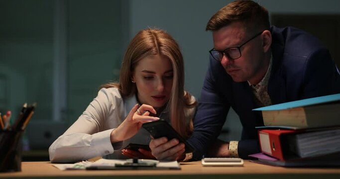 Business colleagues looking for information online on mobile phone in office 4k movie slow motion. Help and support in work concept