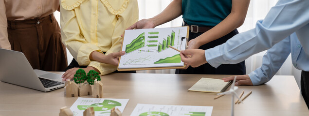 Professional business team presenting green business project by using graph to explain benefit of...