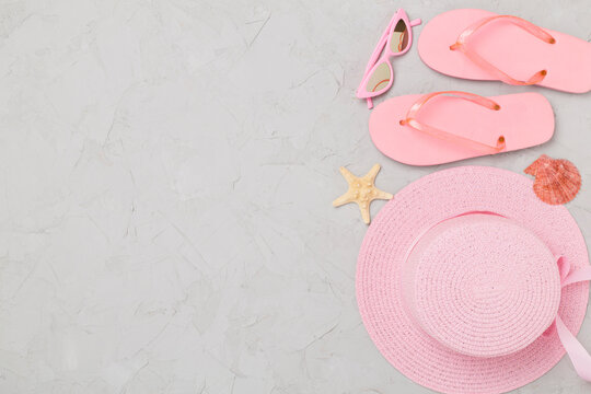 Flat lay with pink summer outfit on concreet background. Vacation concept