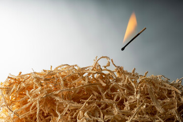 A burning match is the cause of a fire. Flying burning match and pile of sawdust. Fire safety in...