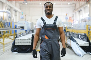 Portrait of African American male engineer in uniform and standing in industrial factory