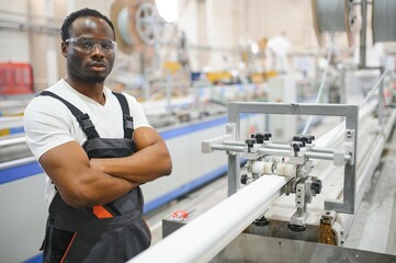 Portrait of African American male engineer in uniform and standing in industrial factory