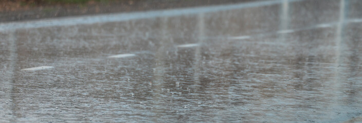 Asphalt road in rainy weather, raindrops on the road