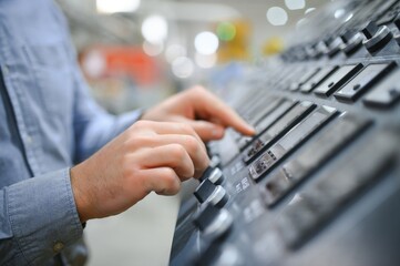 Hand of engineer turn power button on panel control machine