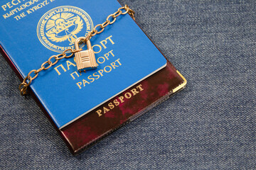 Kyrgyz passport with a chain locked on a padlock  .  Closing borders, Sanctions, ban,  canceling ...