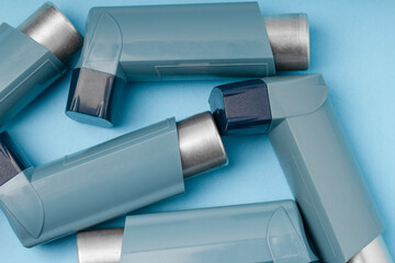 Medicine and breathing disorder concept . Portable asthma inhaler devices on  blue  background