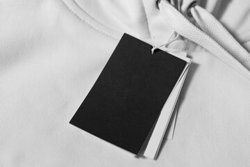 Close-up of a blank tag on white clothing. Resource for mockup design.